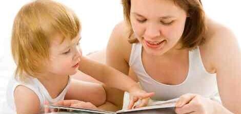 mother and baby in bed read book